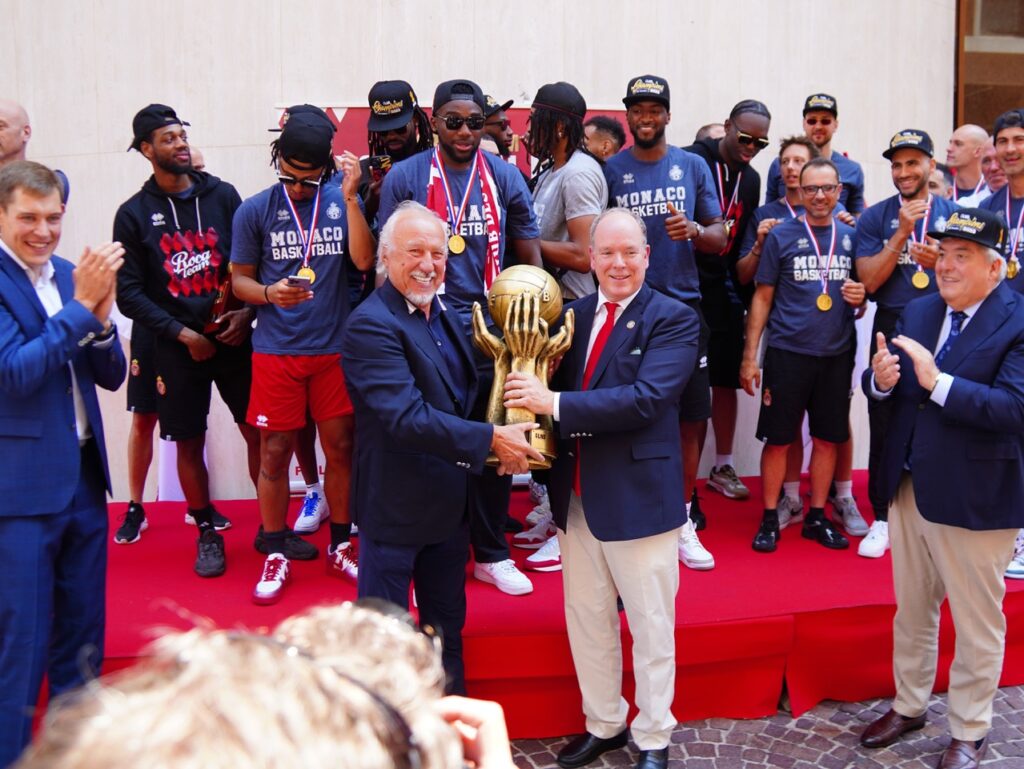 Il Principe  posa con il Presidente del Monaco Basket tenendo il pesantissimo trofeo che la roca Team ha vinto con il Campionato di Francia