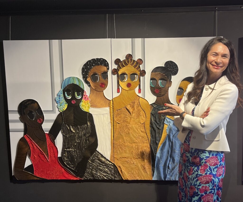La proprietaria della galleria Iro Vharis-Kambanis posa davanti ad una delle opere più interessanti la nigerianaKekere-Ekun Ayobola